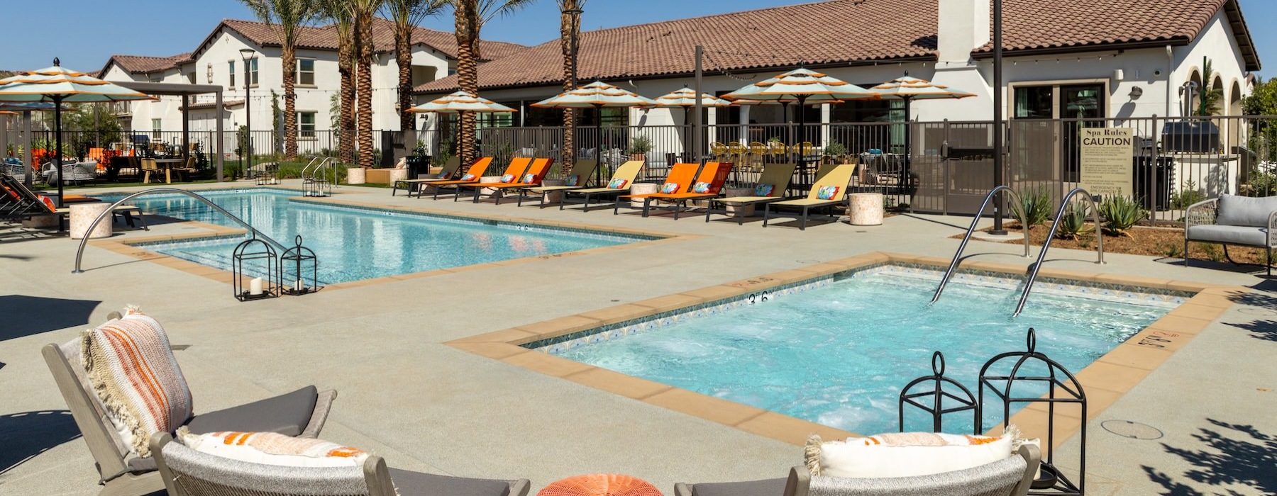 a swimming pool with lounge chairs and umbrellas next to a building