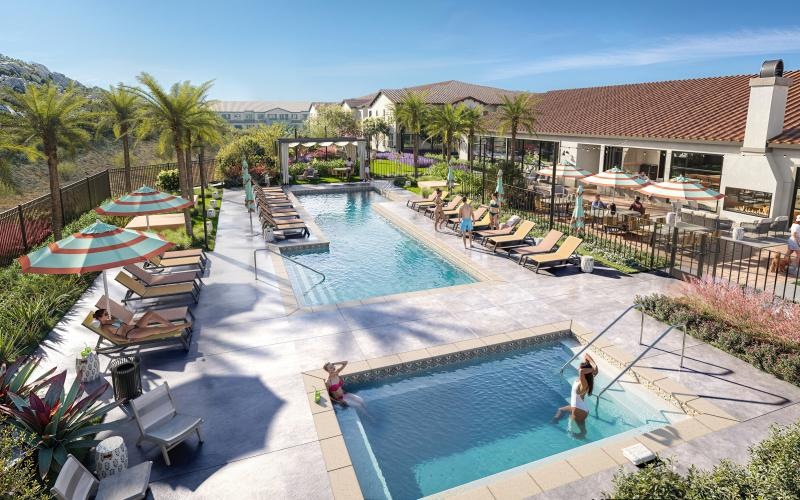 a swimming pool with lounge chairs and umbrellas next to a building